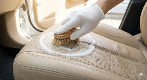 베이지색 가죽 시트를 브러시와 거품으로 세척하는 모습